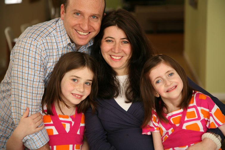 Man and woman with two young daughers wearing matching shirts