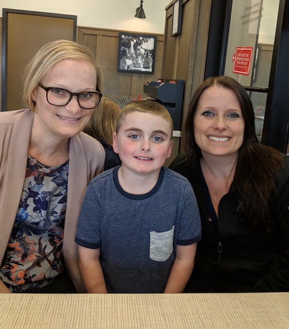 blonde woman with glasses, young boy, woman with brown hair smiling at camera. All have vEDS