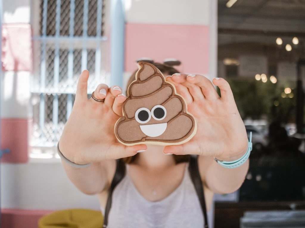 woman holding poop emoji to the camera