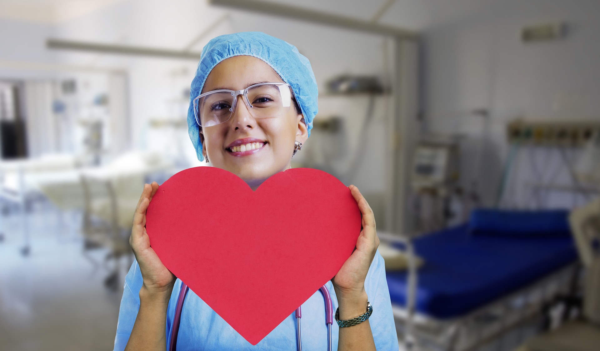 female nurse holding a paper heart and smiling