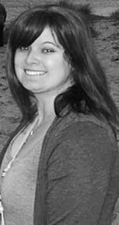 Black and white picture of a woman with VEDS who has dark, long hair and a beautiful smile. 