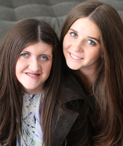 Sydney Lerman and her sister, Carly, smile at the camera.